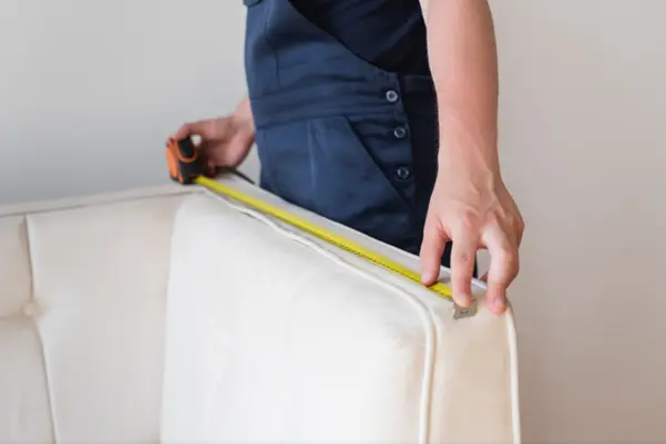 A professional from Z.Mivins carefully measuring a sofa