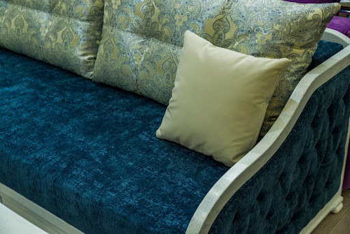  A blue sofa with patterned cushions demonstrating professional pattern matching and texture selection in upholstery