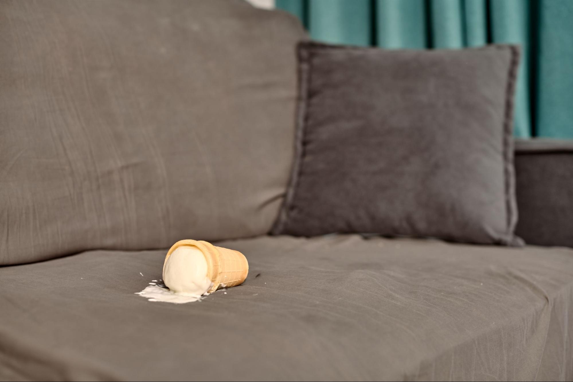 An ice cream cone spilled on a sofa cushion, illustrating common stains and daily wear that lead to upholstery damage.