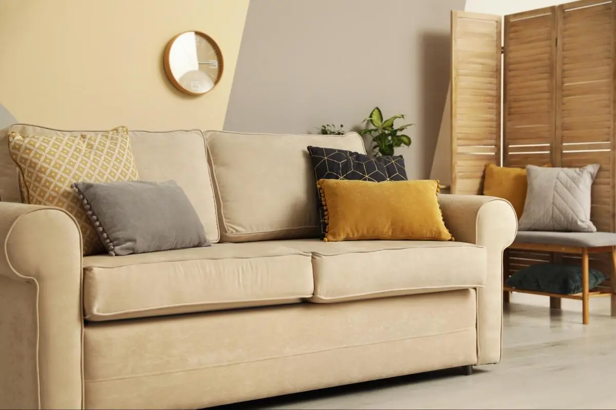 Beige fabric sofa with cushions after reupholstery in a Singapore home