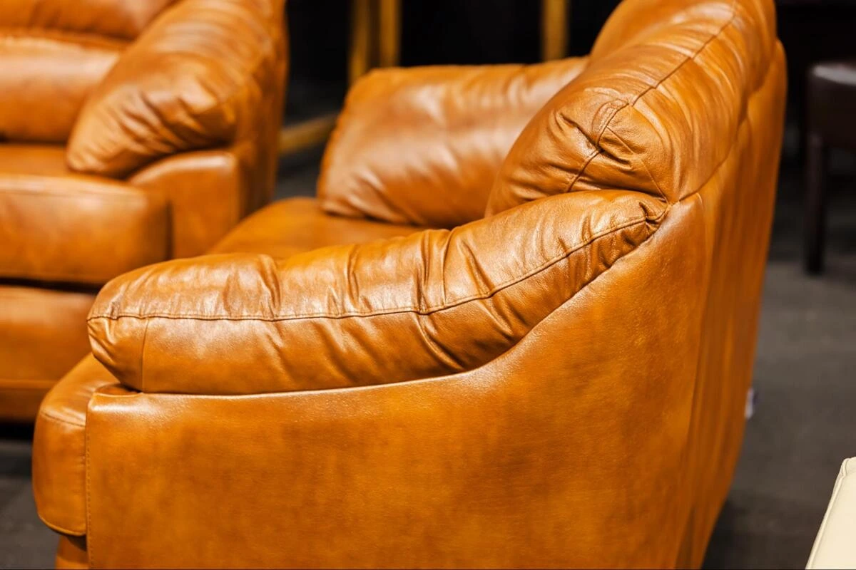 Reupholstering a leather sofa panel Sewing machine stitching a tan leather sofa panel